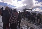 People gather near a helicopter belonging to Nepal Army used to rescue avalanche victims at Thorang-La in Annapurna Region in this October 15, 2014 handout photo provided by Nepal Army.  REUTERS/Nepal Army/Handout via Reuters