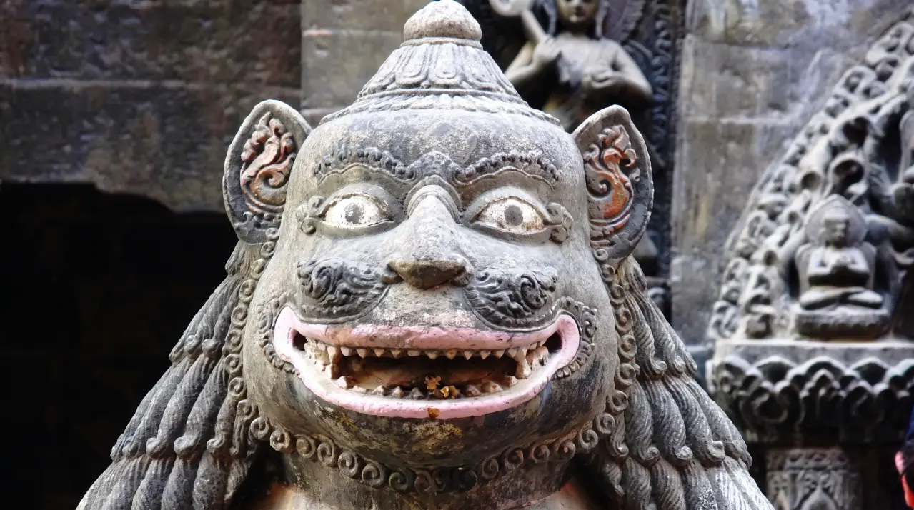 Detailaufnahme eines steinernen Tempelwächters in Kathmandu